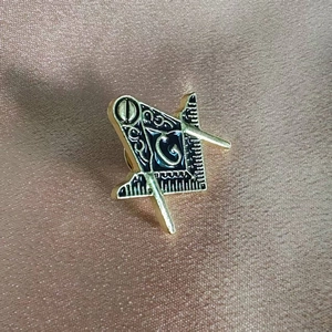 Classic golden Freemasonry enamel pin with square and compasses on satin background