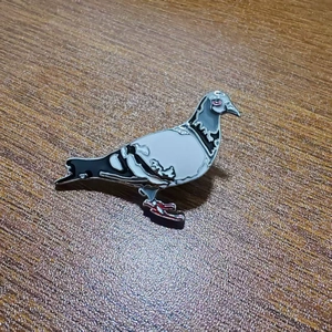 Minimalist metallic pigeon bird brooch pin in grey and white enamel finish with wood background