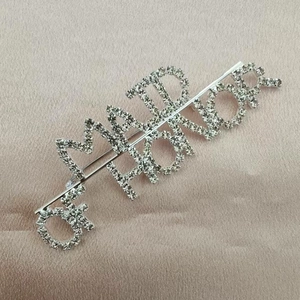 Close-up of Maid of Honor crystal hair clip on a premium champagne satin background