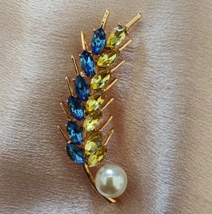 Elegant wheat stalk brooch with blue and yellow crystals and a white faux pearl charm