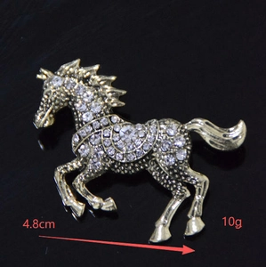 Detail view of horse brooch with white rhinestones and size markings 4.8cm and 10g
