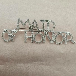 Silver crystal Maid of Honor brooch pin for wedding guests on pink satin background