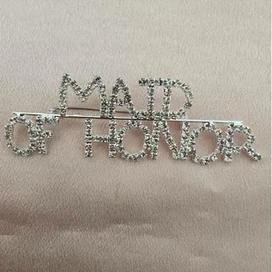 Detail of silver Maid of Honor brooch with sparkling rhinestones for wedding attire