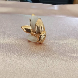 Vue macro d'une broche fleur dorée avec pierres d'opale et pétales texturés fins