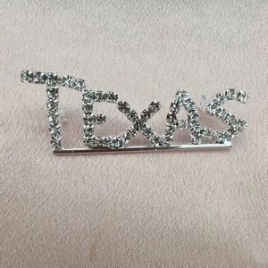 Macro shot of Texas crystal brooch pins with silver metal base on pink silk fabric