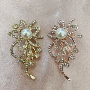Elegante bloemenbrooches met strass-steentjes en parels in goud en roségoud