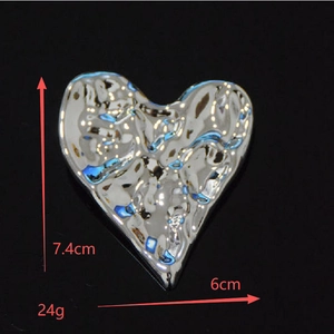 Détail de la broche en forme de cœur montrant 7,4 cm de hauteur et texture martelée
