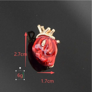 Anatomical red heart brooch with gold accents and dimensions 2.7cm by 1.7cm
