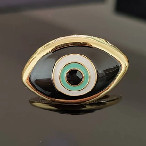 Macro shot of gold-plated evil eye ring detail with enamel inlay and mirror reflection