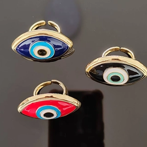 Detailed view of adjustable evil eye rings with colorful enamel finishes in gold tone