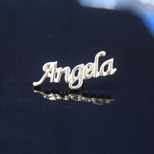 Macro della spilla con nome Angela in metallo dorato con finitura a specchio lucida