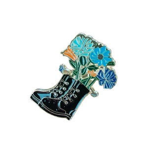Spilla creativa in smalto con stivale stringato nero e fiori blu e arancioni