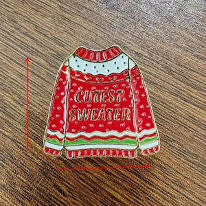 Detailed view showing the 3cm x 3cm enamel Christmas sweater brooch with cutest sweater text
