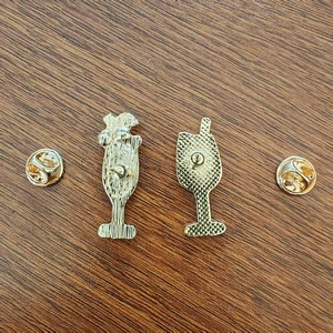 Enamel wine glass lapel pin back view with gold butterfly clutches on wood background