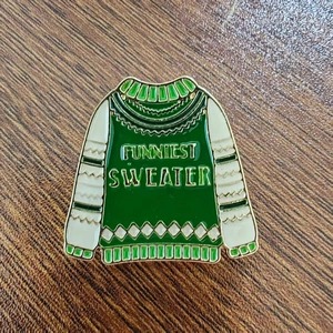 Green Funniest Sweater Christmas enamel pin badge with gold metal plating on wood background