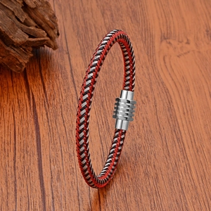 Detail of red, black and silver braided cable bracelet with steel magnetic clasp on wood