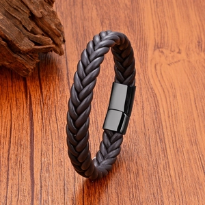 Dettaglio macro del bracciale in pelle nera intrecciata con fibbia magnetica in acciaio