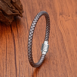 Minimalist woven leather bracelet with geometric stainless steel magnetic clasp on wood