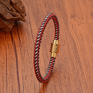 Three-color braided stainless steel bracelet with golden magnetic clasp on wood