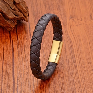 Nahaufnahme eines Lederarmbands mit poliertem Magnetverschluss aus Gold auf Holzfläche