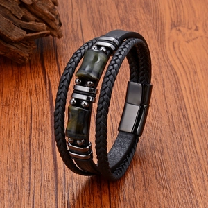 Détail d'un bracelet multicouche en cuir avec pierres œil de tigre et fermoir aimanté
