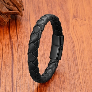 Nahaufnahme von schwarzem Lederarmband mit Magnetverschluss auf einer Holzoberfläche