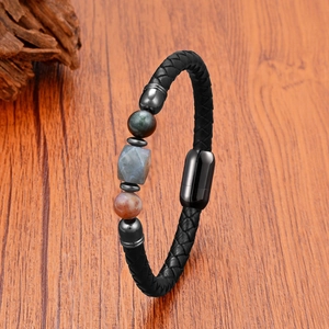 Braided leather bracelet with tiger eye stones and magnetic clasp on wooden background