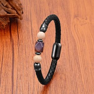 Detailed macro view of woven black leather bracelet with natural stones and magnetic clasp