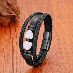 Détail d'un bracelet multicouche en cuir noir avec pierres cœurs roses et fermoir aimanté
