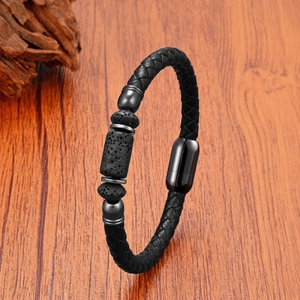 Détail du bracelet en cuir tressé noir avec pierres de lave et fermoir magnétique sur bois