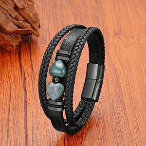 Détail du bracelet en cuir tressé avec deux ornements en pierre naturelle en forme de cœur