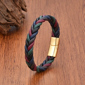 Braided leather bracelet with colorful cords and golden magnetic clasp on wood