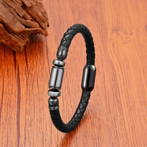 Détail du bracelet en cuir noir tressé avec cinq ornements cylindriques en métal gris