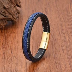 Detail of black and blue braided leather bracelet with golden magnetic buckle on wood
