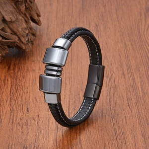 Dettaglio del bracciale in pelle intrecciata da uomo con elementi in metallo grigio