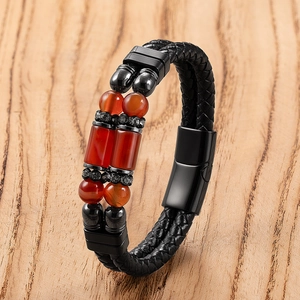 Detailweergave van de gelaagde leren armband met rode steenkralen en zwarte magneetsluiting