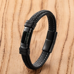 Close-up van zwart gevlochten leren armband met groene marmeren steen en magnetische sluiting
