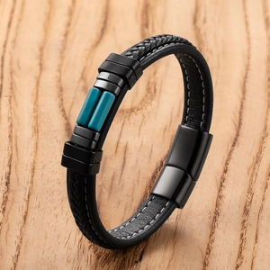 Detail van een zwarte gevlochten leren armband met blauwe stenen en een magnetische sluiting
