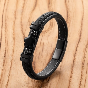 Detail of multi-layer black leather bracelet with four-leaf clover charm and magnetic clasp