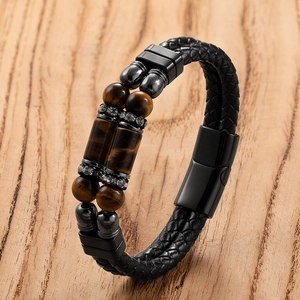 Detail van dubbellaagse zwart gevlochten lederen armband met tijgeroog en magneetsluiting