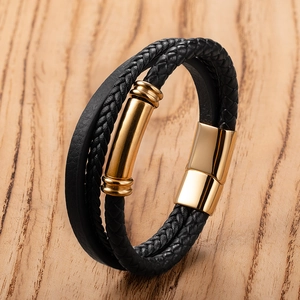 Men's multilayer braided black leather bracelet with gold magnetic clasp on wood base