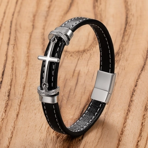 Dettaglio del bracciale da uomo in pelle nera intrecciata con croce in acciaio inossidabile