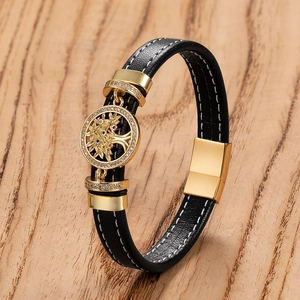Detailed macro view of black leather bracelet with golden Tree of Life charm and stones