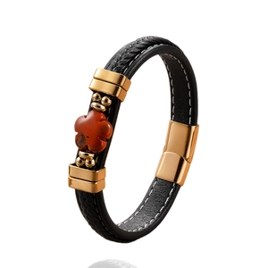 Women's braided black leather bracelet with gold metal accents and red stone flower