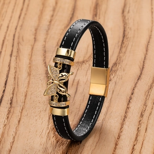 Dettaglio del bracciale in pelle nera con ciondolo a farfalla in cristallo e chiusura oro