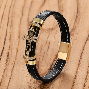 Men's black leather bracelet featuring a gold cross charm and magnetic clasp