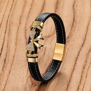 Dettaglio macro del bracciale in pelle nera con fiocco dorato e zirconi cubici