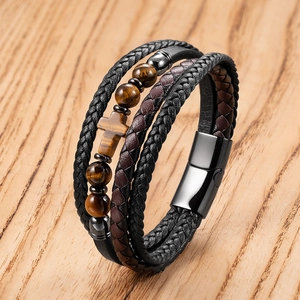 Detail of multi-layer leather bracelet with tiger eye stones and cross charm