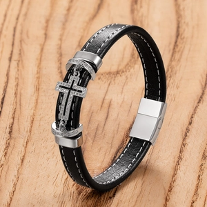 Men's leather cross bracelet with sparkling stones and a magnetic clasp on wood