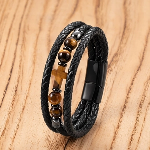 Detail of multi-layer men's braided leather bracelet with tiger eye beads and cross charm